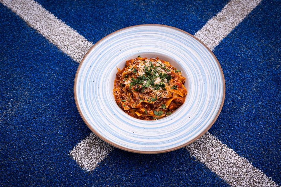 Pasta-Teller auf dem blauen Platz mit weißen Linien